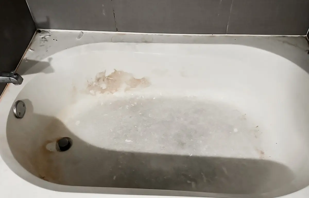 Bathtub with heavy grime and stains before cleaning